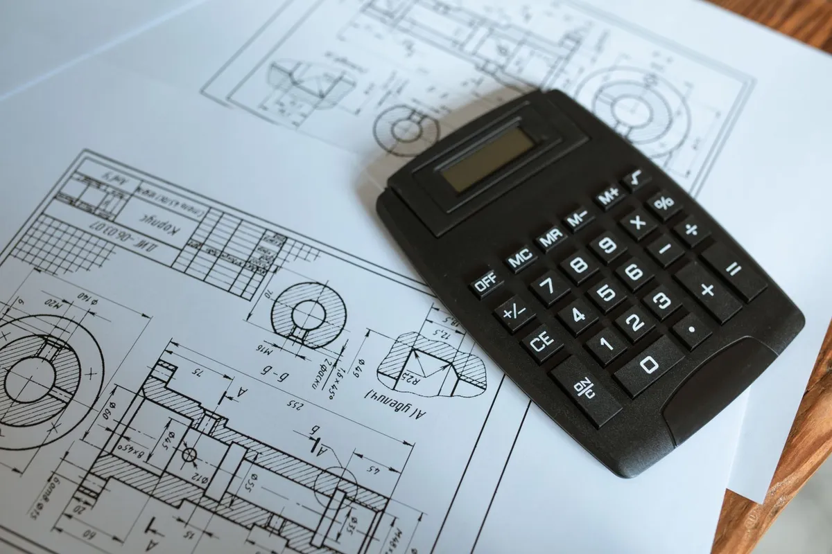 A calculator on a technical drawing of a mechanical part